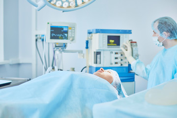 Several doctors surrounding patient on operation table during their work. Team surgeons at work in operating room
