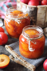 Autumn sweet. Homemade red plums jam in two jars and fruits