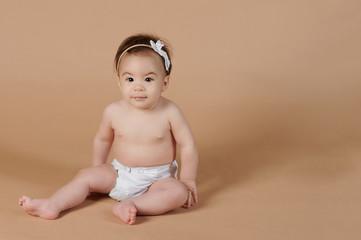 Little girl sitting on studio background