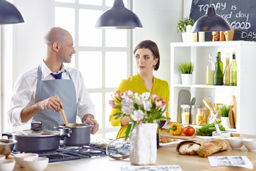 Smiling young couple cooking food in the kitchen