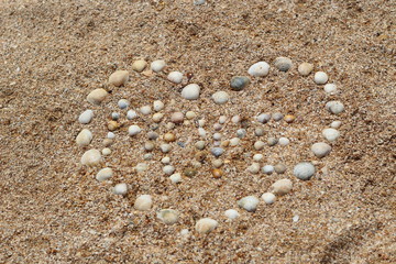 Heart shape maked of sea shells on sand