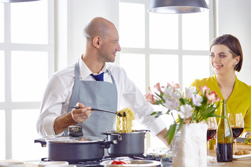 Smiling young couple cooking food in the kitchen