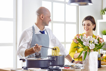 Smiling young couple cooking food in the kitchen