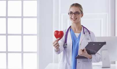 Doctor with stethoscope holding heart, isolated on white background