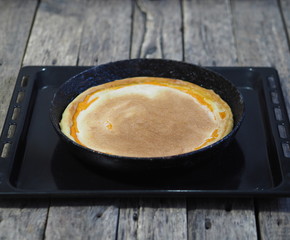 Round homemade pie with pumpkin, chopped walnuts, topped with beaten eggs with sugar in a pan in the oven for baking. Homemade baking.