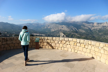 Young woman looks to the beautiful valley and mountains, Guadalest, Spain