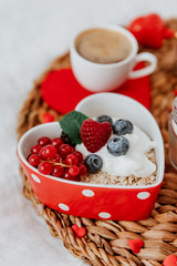 Yogurt with muesli and strawberries in a heart-shaped bowl