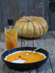 Round homemade pie with pumpkin. Stage of cooking. We spread the filling. Wooden rustic background. Homemade baking.