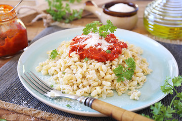 Pearl barley with tomato sauce and grated parmesan cheese