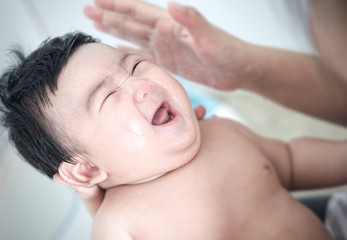 Close up asian baby smiling and bathing with her mother in the bath room
