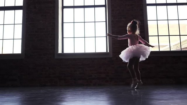 Child Little ballerina in pink tutu dancer. Children's ballet. Slow motion