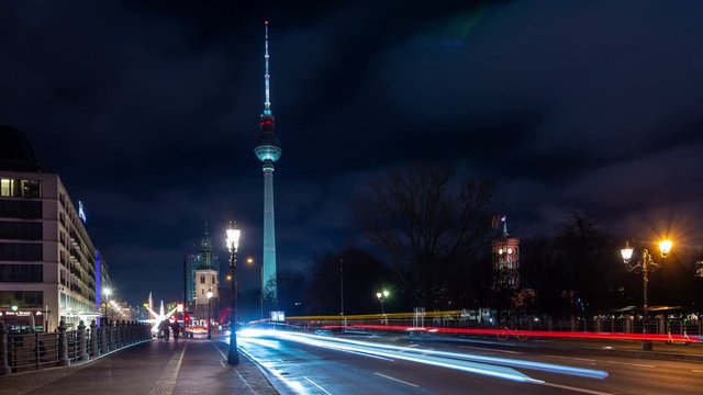 Car traffic in Berlin city center at night. Time lapse video. Panoramic view with illuminated Fernsehturm (Berlin TV tower), one of the most important landmarks of the city.