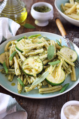 Italian penne pasta with roasted zucchini, pesto sauce and green beans