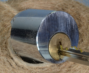 Closeup on pin tumbler lock with semi inserted key.