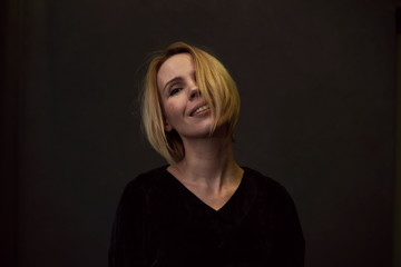 Fototapeta premium Woman is smiling on a dark background.