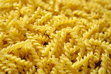 Heap of dried italian spiral shape pasta, closeup. Food background