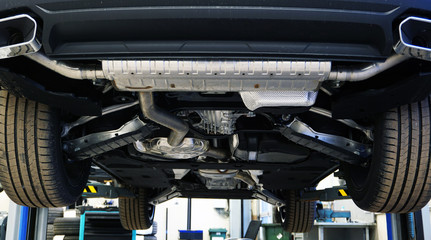 Modern quality car service concept. Modern off-road luxury car on a lift in a car service for...