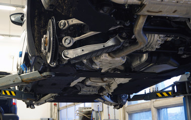 Modern quality car service concept. Modern off-road luxury car on a lift in a car service for repair.