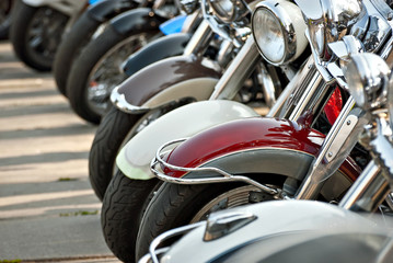 Motorcycles are placed in a row. Headlight closeup. Motorcycle chrome elements.