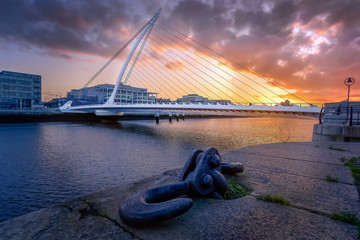 Naklejka premium Amazing sunset and golden hour at Samuel Beckett bridge, resembling a harp. Fine art photography of Dublin cityscape, Ireland