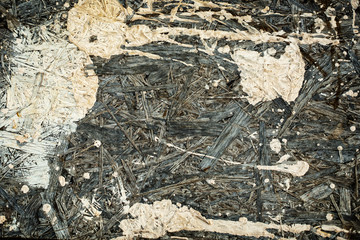 Splashes of light paint on a grey wooden texture.