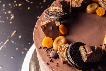 Chocolate cake cutaway on the table, with a decor of sweets