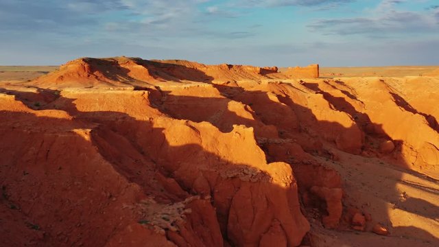 Aerial view of the Bayanzag flaming cliffs at sunset in Mongolia, found in the Gobi Desert, 4k