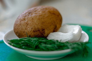 Plate with boiled potatoes, dill and onion. Healthy vegetarian food