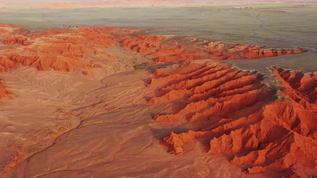Aerial view of the Bayanzag flaming cliffs at sunset in Mongolia, found in the Gobi Desert, 4k