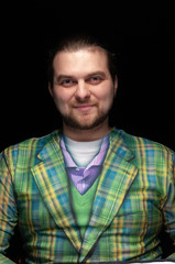 Fototapeta premium portrait of cheerful handsome stylish bearded man in green checkered blazer looking at camera isolated on black