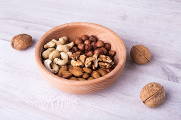 wood serving spoon with Assortment nuts on wooden table. Close-up.
