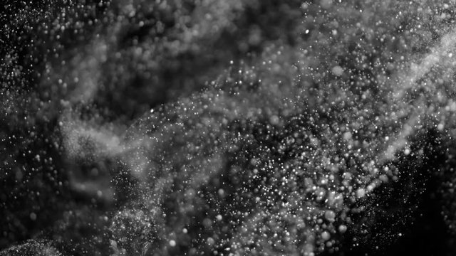 Slow movement of microparticles in the form of small and rounded bubbles on a black background HD