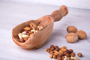 wood serving spoon with Assortment nuts on wooden table. Close-up.