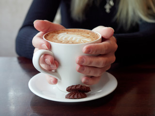 girl holding a Cup of coffee. close up.  cookies