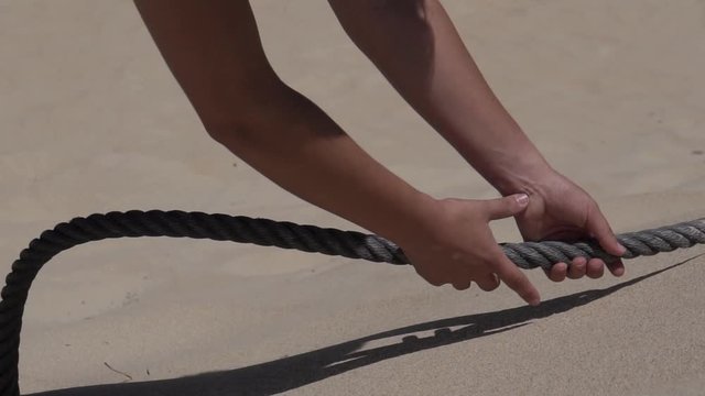 Manos cogiendo cabo enterrado en una duna de arena HD