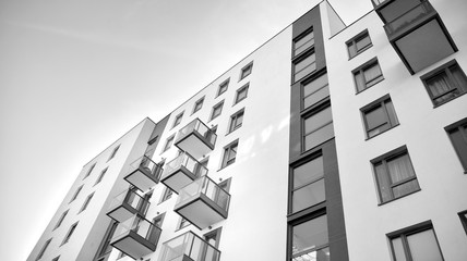 Sun rays light effects on urban buildings. Fragment of modern residential apartment with flat buildings exterior. Detail of new luxury house and home complex. Black and white.