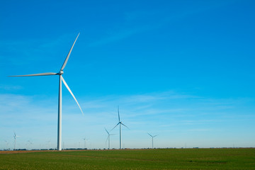 Wind turbines on a plain of green farm fields