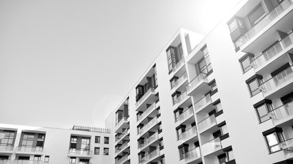 Sun rays light effects on urban buildings. Fragment of modern residential apartment with flat buildings exterior. Detail of new luxury house and home complex. Black and white.