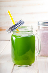 Green healthy smoothie in glass jar on rustik wood