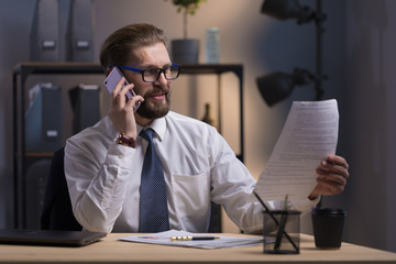 Enthusiastic bearded businessman adjusting contract terms and conditions via smartphone