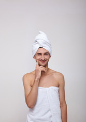 A young white man after a shower winks and smiles.