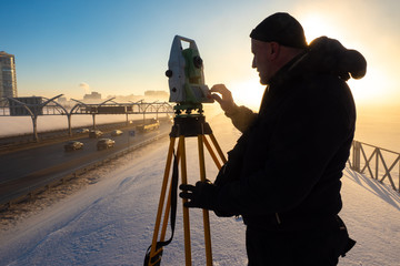 Work surveyor. Man works with theodolite. Theodolite on a tripod. Man and the instrument on the...
