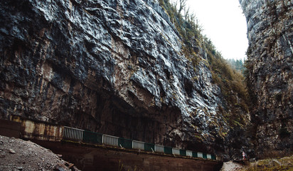 Stone bag Abkhazia in spring. Canyon road surrounded by rocks.Trees grow on a ridge. Cliffy mountains above the road. Unusual place in mountainous areas.