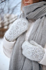 Hands in Knitted Mittens. Winter lifestyle. Wearing Stylish Warm Clothes. Woman in warm clothes
