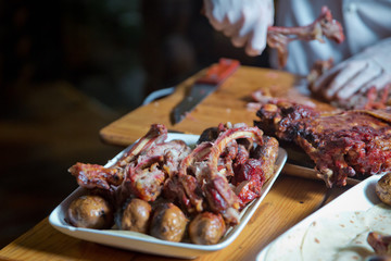 Barbecue is prepared of lamb or sheep meat and processed by slasher. Antrikot and potato kebabs are in a white plate. Roasted meat over an open fire, cooked in a special way.
