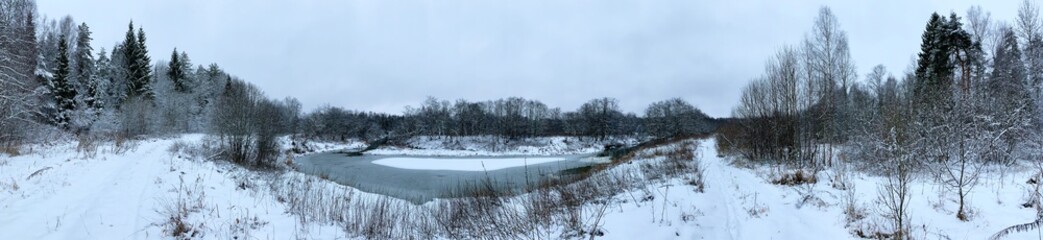 Panoramic view with winter river and snow forest. Beautiful winter landscape