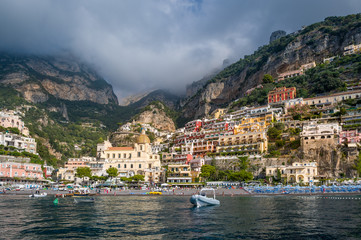 Fototapeta na wymiar Positano bay with beach, old town on the hill. Mountain range at the background. Amalfi coast, Italy.