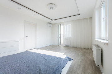 Simple exclusive white bedroom with wooden parquet