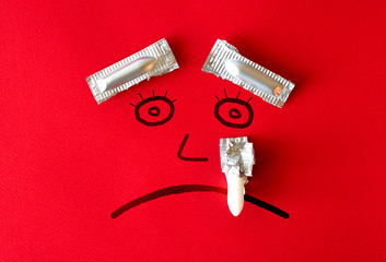 Hemorrhoid concept with painted sad face with eyebrows and a tear from suppository for anal use