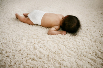 Obraz na płótnie Canvas a baby sleeping on the white carpet